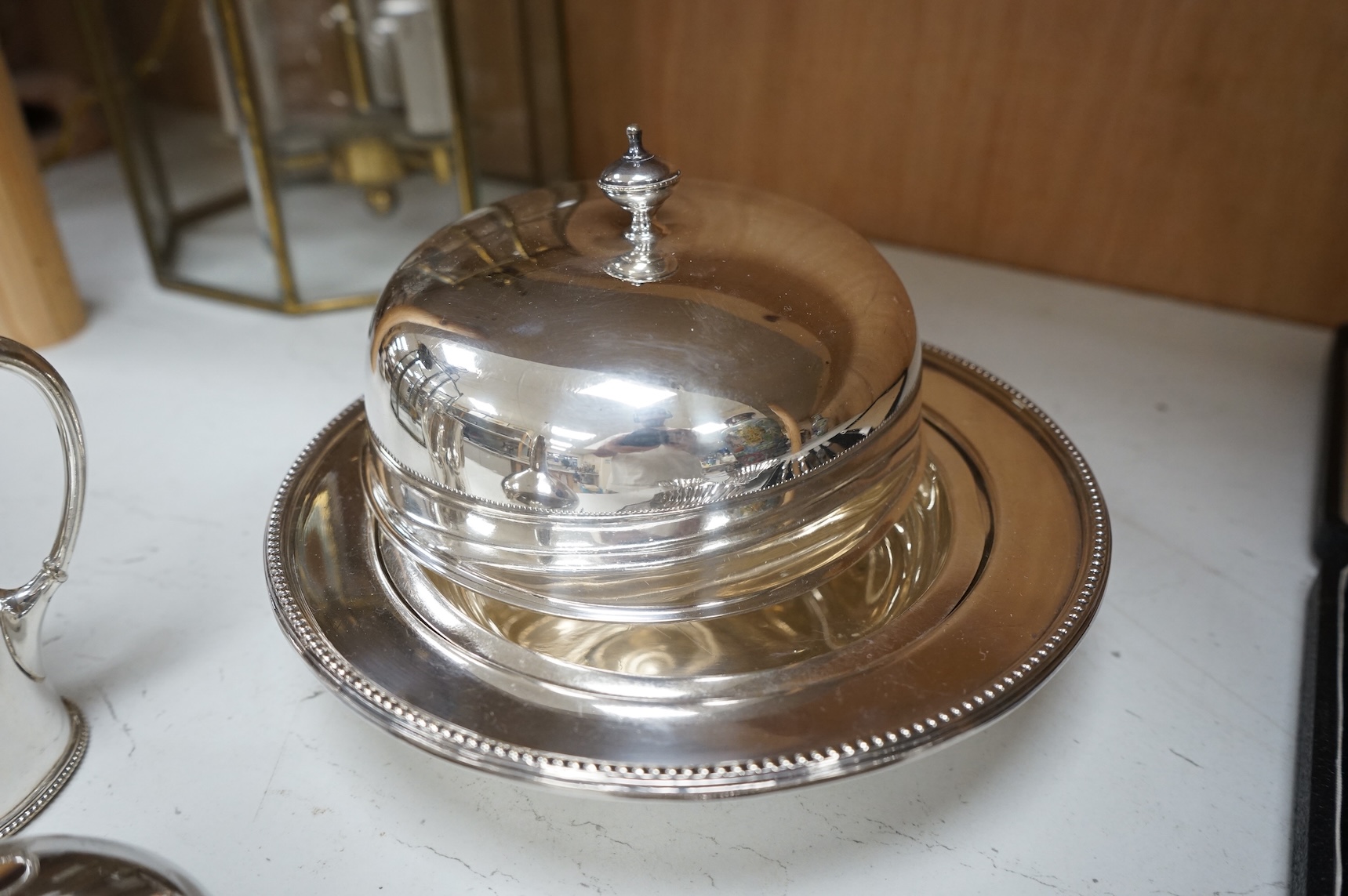 A Mappin plated muffin dish and six other plated items including three Old Sheffield plate butter shells, a wine funnel, Elkington & Co cream jug and cased set of tea knives.